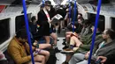 Orang-orang mengambil bagian dalam 'No Trousers On The Tube Day' atau No Pants Subway Ride di London Underground,  pusat Kota London, Minggu (12/1/2020). Untuk tahun ini, acara naik kereta tanpa celana itu dilangsungkan serentak di sejumlah kota dunia pada 12 Januari. (DANIEL LEAL-OLIVAS/AFP)