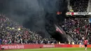 Asap hitam menyelimuti tribun penonton saat pertandingan sepak bola PSV Eindhoven vs Ajax dalam pertandingan Liga Eredivisie di Stadion Philips, Belanda (23/4). Asap hitam tebal tersebut sempat mengganggu jalannya pertandingan. (Olaf KRAAK / ANP / AFP)