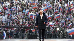 Presiden Rusia Vladimir Putin tiba untuk menyampaikan pidatonya di konser perayaan  delapan tahun referendum tentang status negara bagian Krimea dan Sevastopol serta penyatuannya kembali dengan Rusia, di Moskow, Rusia (18/3/2022). (Mikhail Klimentyev, Sputnik, Kremlin Pool Photo via AP)