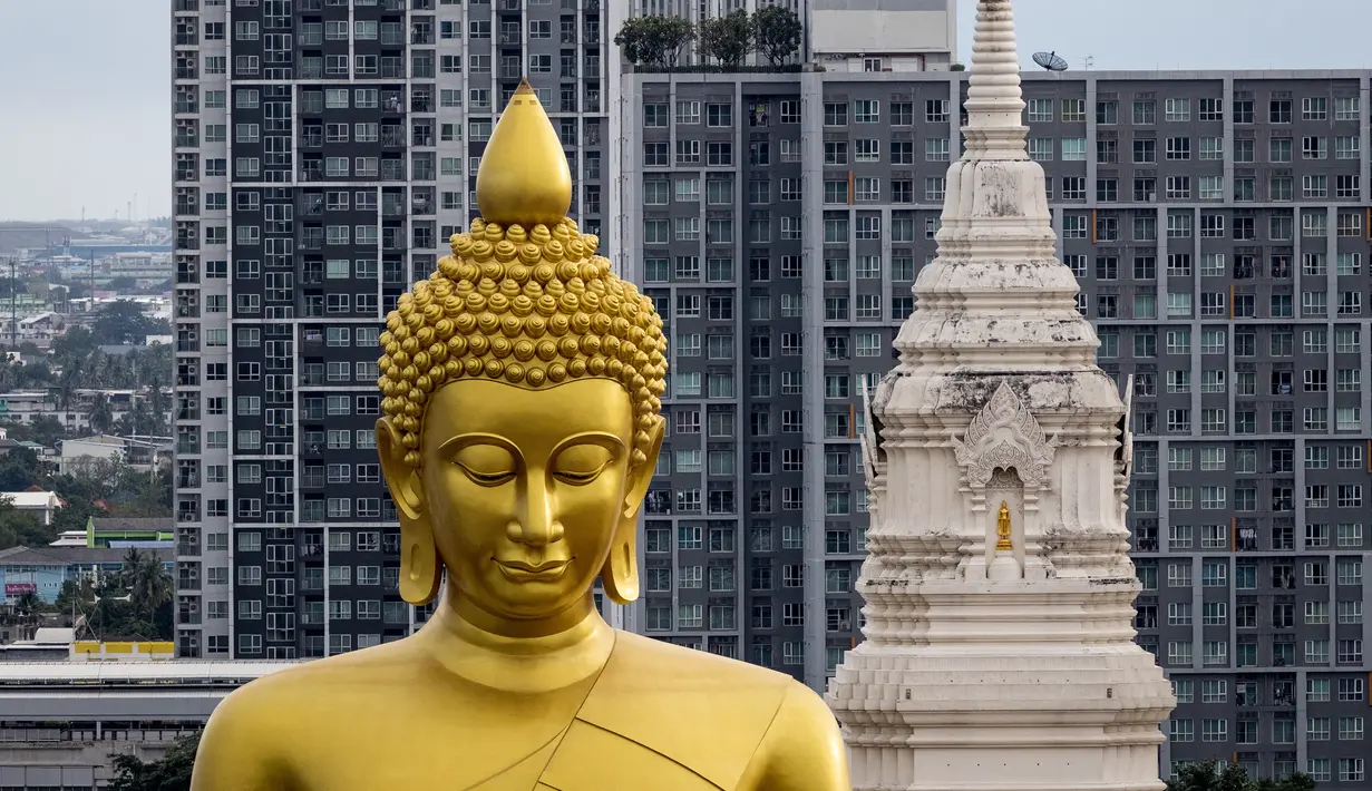 Patung Buddha raksasa setinggi 69 meter berdiri di kuil Wat Paknam Phasi Charoen di pinggiran Bangkok, Thailand pada Selasa (12/10/2021). Kuil Wat Paknam Phasi Charoen yang dibangun pada 1610 memutuskan untuk membangun patung untuk menghormati agama Buddha. (Jack TAYLOR / AFP)