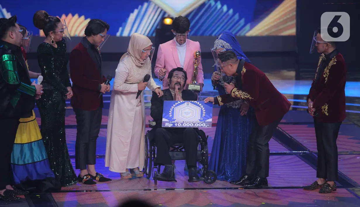 Penyanyi dangdut senior Hamdan ATT mendapatkan penghargaan Lifetime Achievement dalam acara Indonesian Dangdut Awards 2021 di Studio 5 Indosiar, Jakarta, Rabu (1/12/2021). Penghargaan diberikan atas dedikasi Hamdan ATT untuk musik dangdut di tanah air. (Liputan6.com/Faizal Fanani)