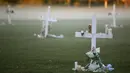 Lilin ditempatkan pada salib untuk menghormati korban pembunuhan massal di Sekolah Marjory Stoneman Douglas, Pine Trail Park, Florida (16/2). Polisi menangkap mantan mahasiswa Nikolas Cruz (19) karena membunuh 17 orang. (Mark Wilson / Getty Images / AFP)