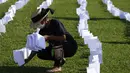 Seorang aktivis menempatkan bendera putih yang mewakili orang yang telah meninggal karena COVID-19 di Brasil, di luar Kongres di Brasilia, Jumat (15/10/2021). Sebanyak 600 bendera, masing-masing dengan nama seseorang, mewakili 600.000 total korban yang telah meninggal. (AP Photo/Eraldo Peres)