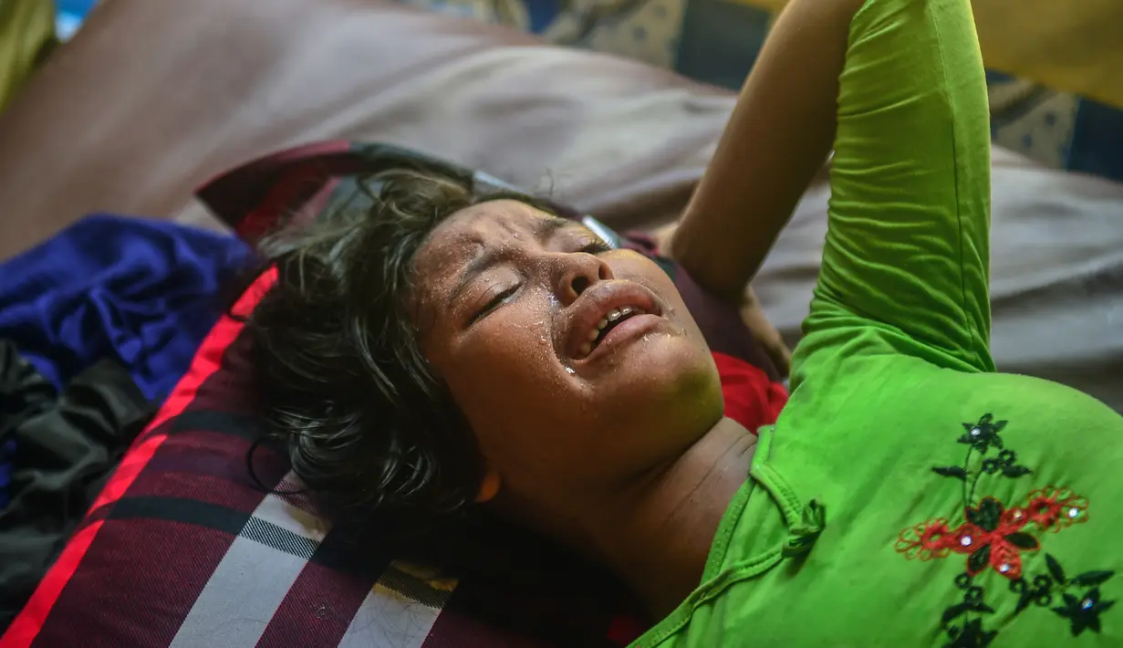 Ekspresi Hasina Aktar saat melahirkan di sebuah pusat medis di kamp pengungsian Kutupalong (11/10). Hasina Aktar berhasil melahirkan seorang bayi laki-laki yang diberi nama Mohammed Jubayed. (AFP Photo/Munir Uz Zaman)