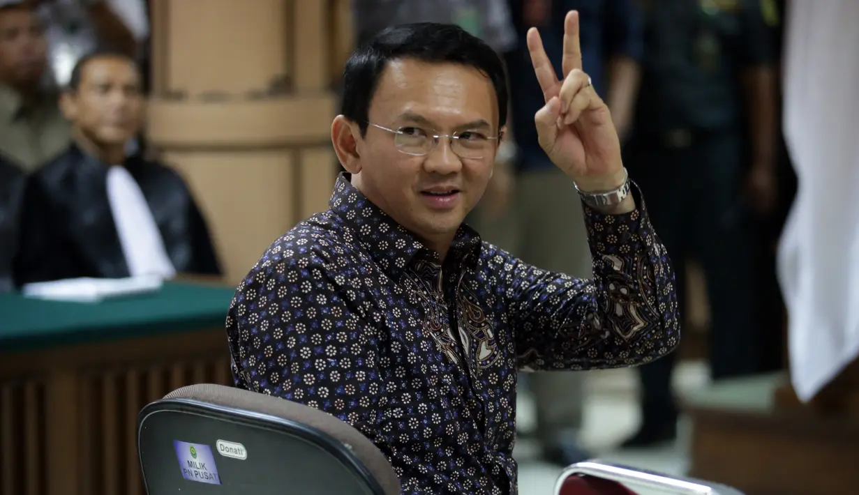 Terdakwa kasus dugaan penistaan agama Basuki Tjahaja Purnama (Ahok) memberikan salam dua jari sebelum dimulainya sidang lanjutan di PN Jakarta Utara, Selasa (26/12). Sidang ini beragenda putusan sela dari majelis hakim. (Liputan6.com/Bagus Indahono/Pool)
