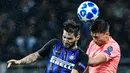 Gelandang Inter Milan, Matteo Politano, duel udara dengan bek Barcelona, Clement Lenglet, pada laga Liga Champions di Stadion San Siro, Milan, Selasa (6/11). Kedua klub bermain imbang 1-1. (AFP/Miguel Medina)