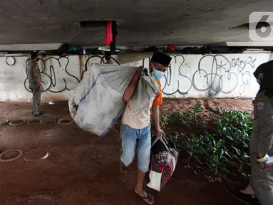 Petugas Satpol PP melakukan razia kepada para tunawisma di bawah flyover Jatinegara, Jakarta Timur, Senin (19/7/2021). Razia ini merupakan upaya dari Kecamatan Jatinegara di kawasan Kampung Melayu untuk bersih dari tunawisma yang sering tidur dan berjualan.  (Liputan6.com/Johan Tallo)