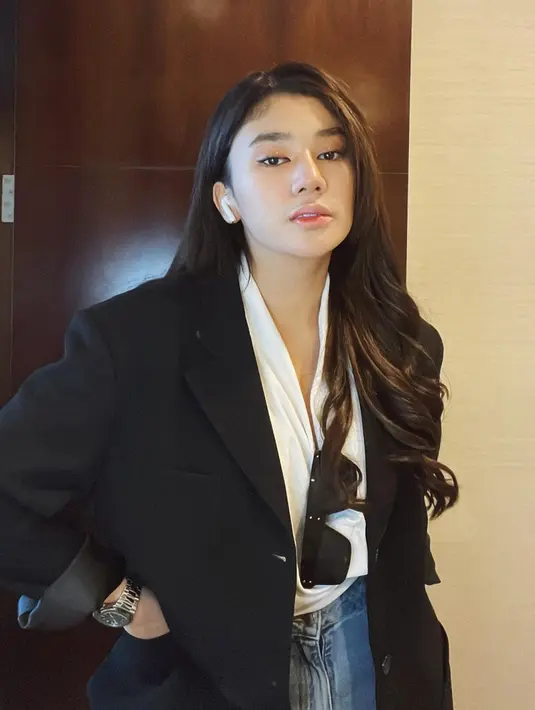 Clara Shinta mengenakan blouse putih yang dipadukan dengan blazer hitam. TikToker tersebut juga menambahkan aksesoris kacamata hitam. (Instagram/@clarashintareal)