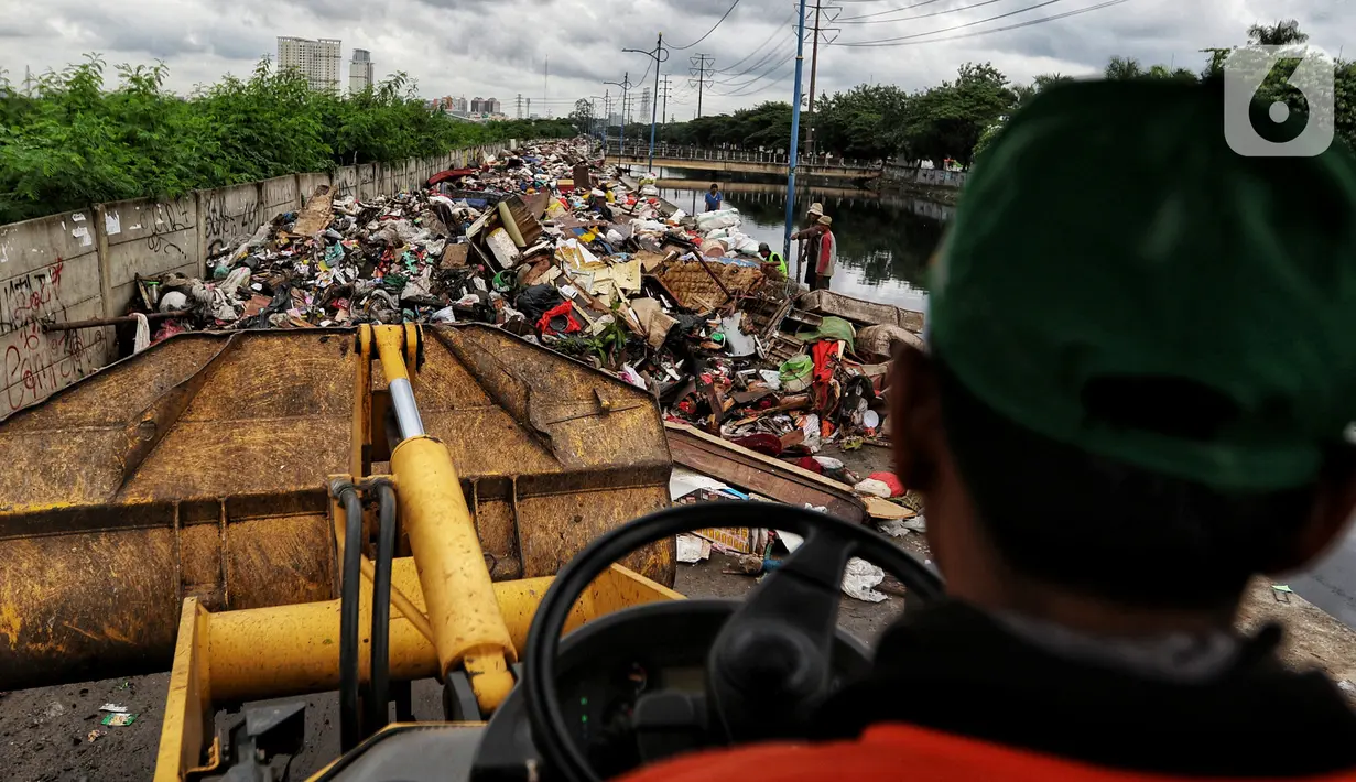 Petugas PPSU menggunakan alat berat mengumpulkan sampah sisa banjir di sepanjang Kali Cengkareng, Jakarta Barat, Kamis (9/1/2020). Tumpukan sampah di sepanjang bantaran kali dan rumah-rumah warga terlihat setelah banjir yang melanda sejumlah kawasan Jakarta mulai surut. (Liputan6.com/Johan Tallo)