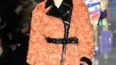 Model AS, Gigi Hadid berjalan mengenakan koleksi terbaru Moschino di panggung runway Milan Fashion Week 2018, Rabu (21/2). Gigi Hadid terlihat dengan koleksi coat warna oranye dengan patent leather trim dan topi yang senada bahannya. (Miguel MEDINA/AFP)