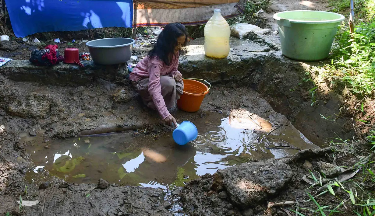 Seoarang anak mengambil air dari mata air yang bercampur lumpur di Kampung Cijaura, Desa Cidokom, Bogor, Jawa Barat, Minggu (26/07/2026). (KLY/ Arie Basuki)