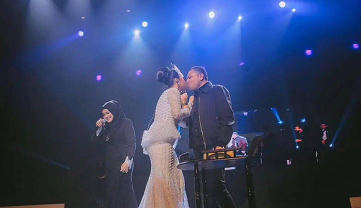"Terimakasih banyak sayangku @raullemos06," tulis KD dalam foto ciuman diatas panggung. Dari foto terlihat, di sebelahnya Diva Malaysia, Siti Nurhaliza terlihat sedang tertunduk sembari tersenyum. (Instagram/krisdayantilemos)