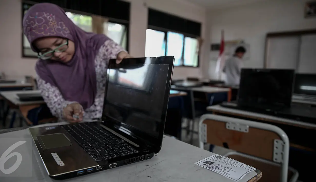 Petugas menyiapkan komputer/laptop  untuk ujian nasional berbasis komputer (computer based test/CBT) di SMP N 1, Jakarta, (7/5/2016). Ujian Berbasis komputer ini serentak dilaksanakan pada tanggal 9-12 Mei 2016. (Liputan6.com/Faizal Fanani)