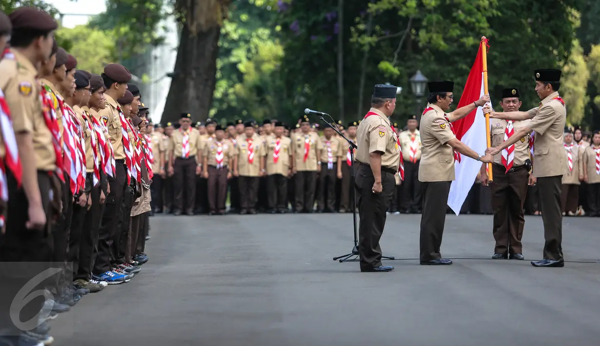 Presiden Jokowi (kanan) menyerahkan bendera merah putih kepada Ketua Kwarnas Gerakan Pramuka Adhyaksa Dault saat pelepasan 462 kontingen Pramuka Indonesia yang akan mengikuti Jambore Pramuka Dunia ke-23, Jakarta, Jumat (24/7). (Liputan6.com/Faizal Fanani)