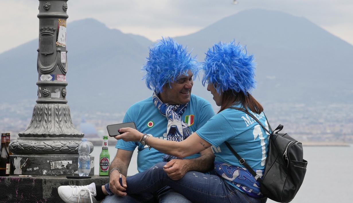 Sepasang fans Napoli bersukacita diluar stadion setelah tim kesayangannya mencetak gol ke gawang Salernitana pada menit ke-62. (AP Photo/Gregorio Borgia)