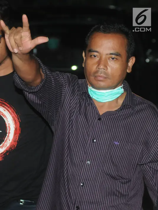 Bupati Purbalingga Tasdi mengacungkan salam saat tiba di Gedung KPK, Jakarta, Selasa (5/6). Tasdi terjaring Operasi Tangkap Tangan KPK terkait kasus dugaan suap proyek infrastruktur di Kabupaten Purbalingga, Jawa Tengah. (Merdeka.com/Dwi Narwoko)