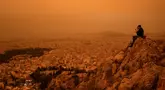 Langit di Yunani selatan berubah menjadi oranye pada hari Selasa ketika awan debu yang tertiup melintasi Laut Mediterania dari Afrika Utara menyelimuti Acropolis dan landmark Athena lainnya. (Angelos TZORTZINIS / AFP)