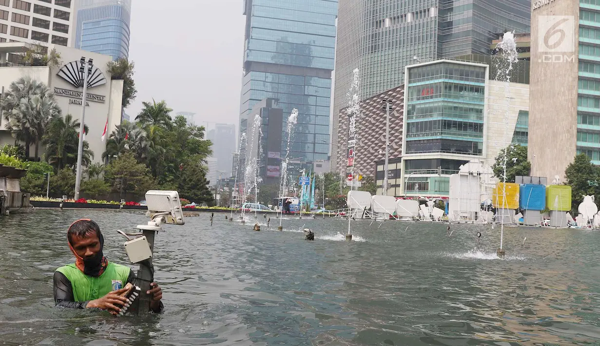 Petugas membersihkan kolam Patung Selamat Datang di kawasan Bundaran HI, Jakarta, Kamis (23/8). Pembersihan dilakukan dalam rangka perawatan rutin guna menjaga keindahan estetika kota. (Liputan6.com/Immanuel Antonius)