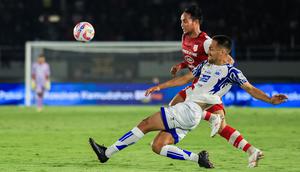 Kapten Persis Solo, Rian Miziar, saat berebut bola dengan pemain asing PSIS Semarang dalam duel Derbi Jawa Tengah yang berlangsung di Stadion Manahan, Solo, Sabtu (17/8/2024). (Bola.com/Radifa Arsa)