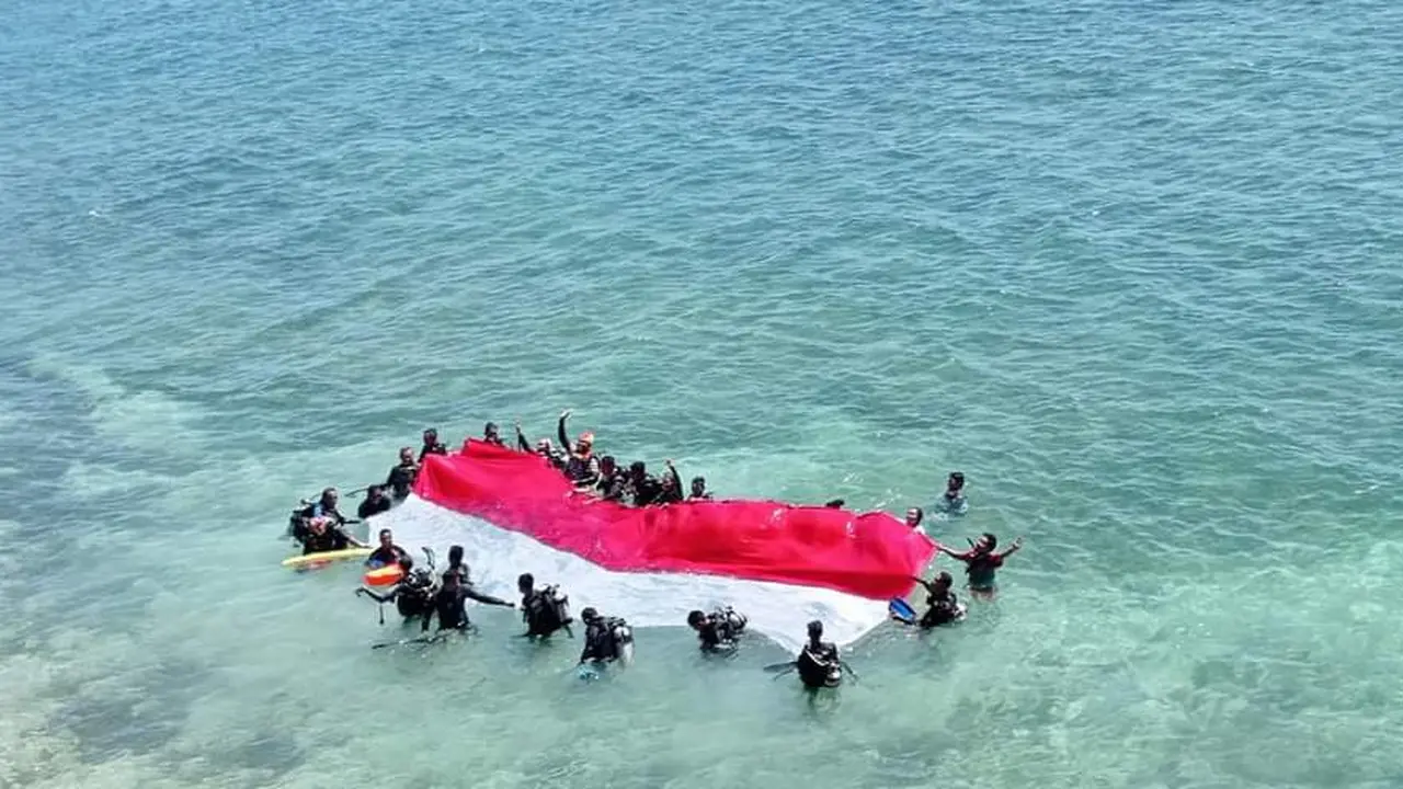 Bendera merah putih, dibawa  20 penyelam untuk dikibarkan di dalam laut Tanjung Kajuwulu. (Liputan6.com/ Dionisius Wilibardus)