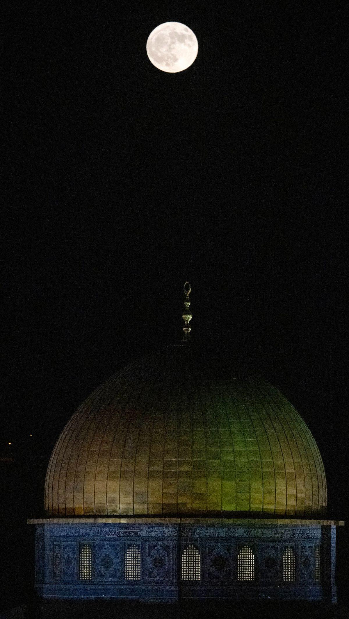 Supermoon langka bersinar menerangi langit di atas kompleks Masjid Al Aqsa, Yerusalem, pada Senin (19/8/2024). Foto: Ronaldo&nbsp;Schemidt/AFP