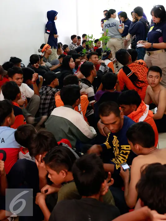 Puluhan pendukung Persija atau The Jakmania ditangkap polisi di Polda Metro Jaya, Jakarta, Minggu (18/10/2015). Para Jakmania itu ditangkap di Ratu Plaza karena menimpuki mobil polisi sampai rusak.  (Liputan6.com/Yoppy Renato)
