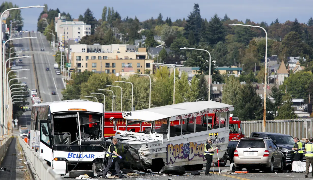 Petugas melakukan penyelidikan di lokasi kecelakaan antara bus carter mahasiswa dengan kendaraan wisata amfibi di sebuah jembatan di Seattle, AS, Kamis (25/9). Kecelakaan itu menewaskan satu WNI bernama Privando Eduardus Putradanto.(REUTERS/Jason Redmond)
