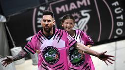 Seorang gadis membawa potongan karton berbentuk pemain baru Inter Miami, Lione Messi saat menunggu di luar Stadion DRV Pink, Miami, 11 Juli 2023. Transfer Messi menjadi paling menggemparkan pada musim panas 2023/2024. La Pulga memilih hengkang dari PSG menuju Inter Miami. Klub milik legenda sepak bola Inggris, David Beckham tersebut diketahui rela merogoh kocek 35 juta euro untuk mendatangkan sang bintang Argentina tersebut. (AP Photo/Rebecca Blackwell)