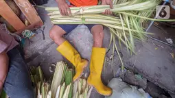 Pedagang membuat kulit ketupat dari anyaman daun kelapa muda (janur) di Pasar Pondok Labu, Jakarta Selatan, Kamis (30/7/2020). Pedagang musiman kulit ketupat yang sebagian datang dari Serang, Banten mulai ramai memadati kawasan Pasar Pondok Labu. (Liputan6.com/Fery Pradolo)