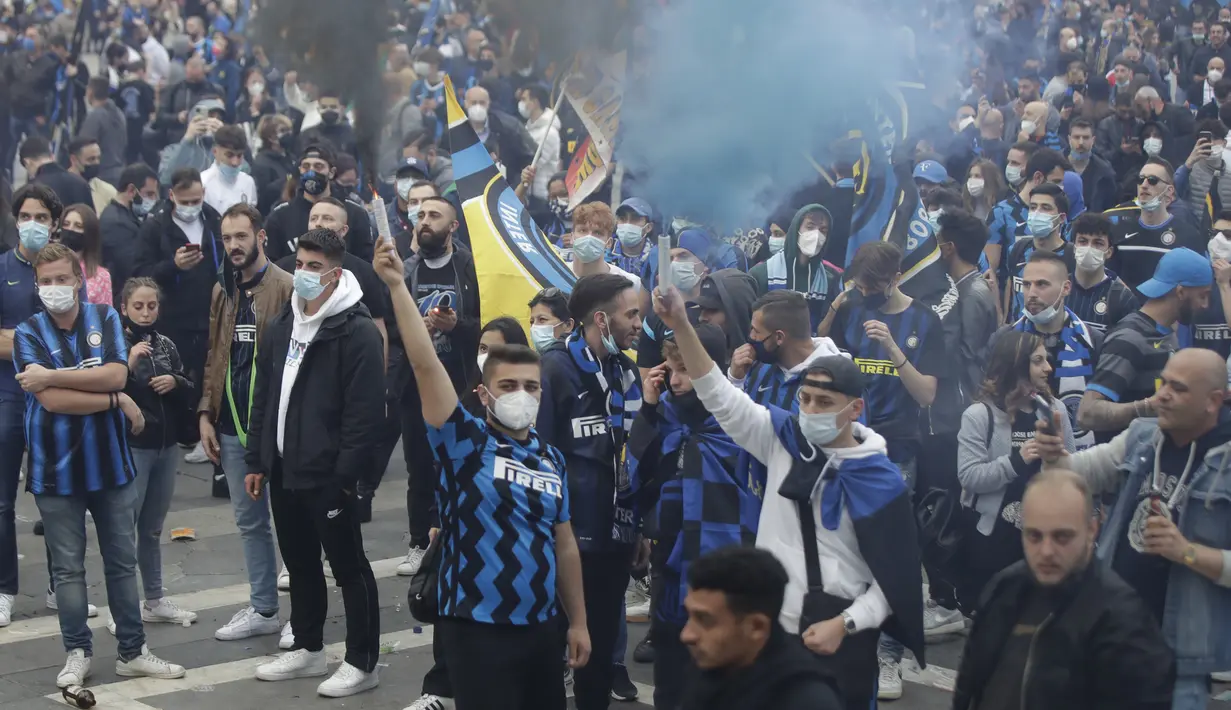 Suporter Inter Milan merayakan dan berteriak di alun-alun Piazza Duomo di depan katedral gotik setelah Inter Milan memenangkan gelar Serie A pertamanya dalam lebih dari satu dekade setelah tim urutan kedua Atalanta bermain imbang 1-1 di Sassuolo, di Milan, Italia (2/5/2021). (AP Photo/Luca Bruno)