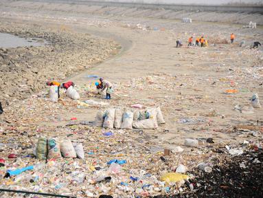 Warga membersihkan tumpukan sampah di sekitar Sungai Yangtze, Taicang, Jiangsu, Tiongkok (23/12). Pulau yang berada dekat Shanghai ini berubah menjadi lautan sampah yang diperkirakan mencapai 100 ton. (REUTERS/Stringer)