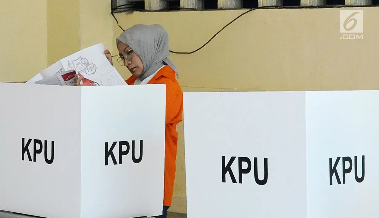 Terdakwa kasus penyebaran berita bohong atau hoaks, Ratna Sarumpaet saat di bilik suara di TPS 15 rutan Polda Metro Jaya, Rabu (17/4). Ratna Sarumpaet tiba mengenakan baju tahanan berwarna oranya bersama 538 tahanan menggunakan hak suaranya pada Pemilu 2019. (Liputan6.com/Herman Zakharia)
