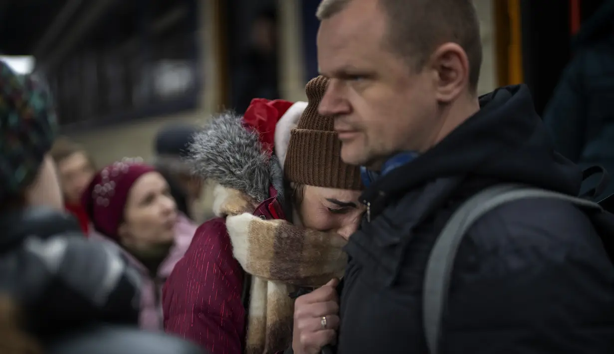 Seorang perempuan menangis saat mengucapkan selamat tinggal kepada suaminya sebelum naik kereta menuju Lviv di stasiun Kiev, 3 Maret 2022. Pria Ukraina harus tinggal untuk berperang sementara wanita dan anak-anak pergi negara untuk mencari perlindungan di negara tetangga (AP Photo/Emilio Morenatti)