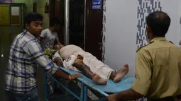 Pegawai Rumah Sakit Siliguri membantu korban luka saat gempa di Siliguri, India, Rabu (13/4). Gempa bumi berkekuatan 6,9 SR mengguncang Mynamar, besarnya guncangan gempa terasa sampai India. (Diptendu DUTTA/AFP)