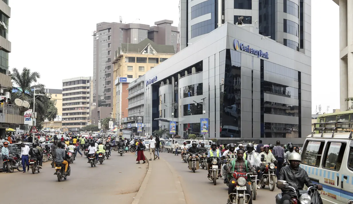 Para pemuda yang duduk di atas sepeda motor terlihat linglung di tengah panas pagi. Tetapi saat melihat calon penumpang, mereka dengan marah menghidupkan mesin mereka dan mencoba saling berlomba untuk mendapatkan bisnis. (AP Photo/Hajarah Nalwadda)