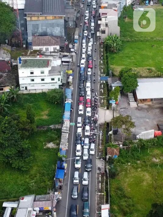 <p>Foto udara memperlihatkan kendaraan wisatawan di Jalan Raya Puncak, Cisarua, Kabupaten Bogor, Jawa Barat, Kamis (5/5/2022). Kapolres Bogor AKBP Iman Imanuddin mengatakan kepadatan arus kendaraan dari arah Jakarta atau Bogor dan juga dari arah Cianjur ke kawasan Puncak masih akan terjadi hingga akhir pekan nanti. (Liputan6.com/Herman Zakharia)</p>