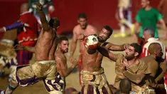 Pemain berebut bola saat pertandingan Calcio Storico Fiorentino di Piazza Santa Croce di Florence, Italia (24/6). Calcio Storico secara harafiah berarti “sepak bola kuno”. Permainan ini berasal dari abad 15. (AFP Photo/Filippo Monteforte)