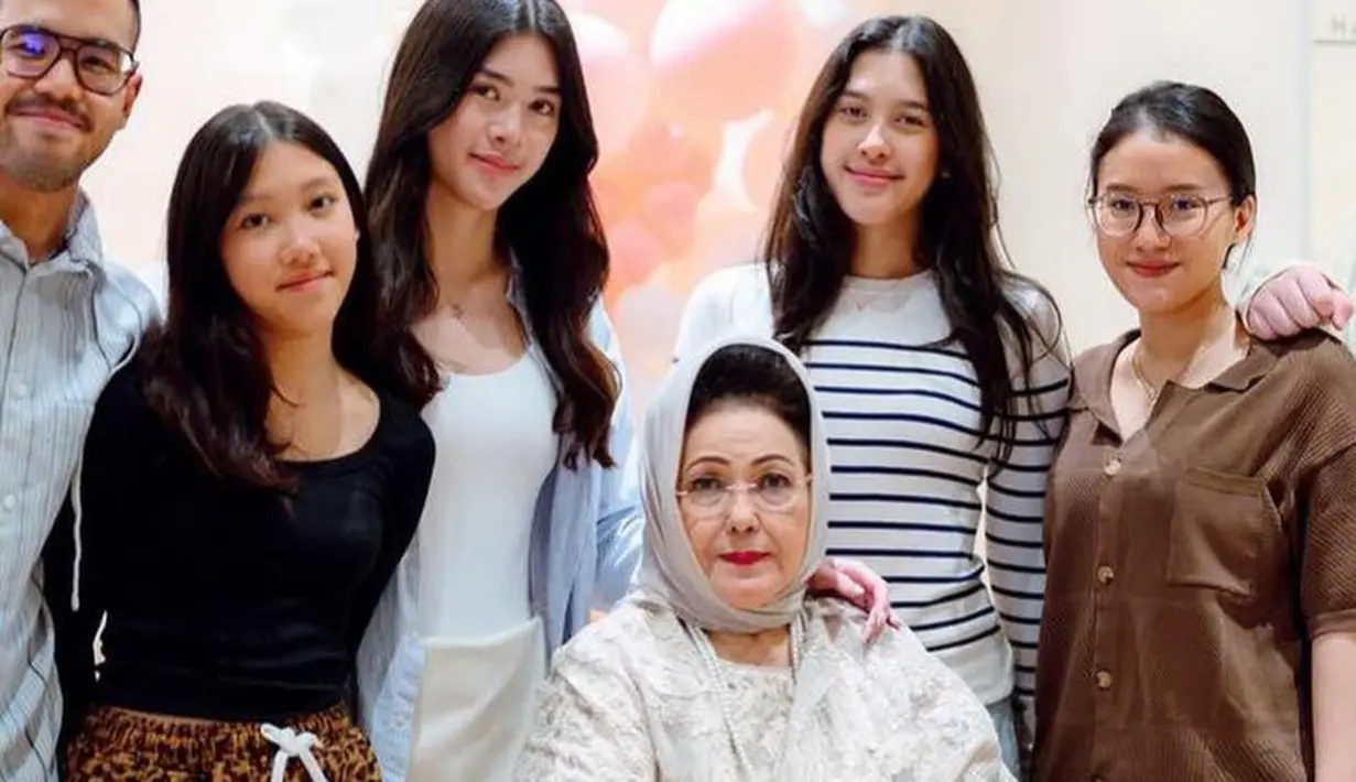 Berfoto dengan cucu-cucunya, ibunda Mieke tampak mengenakan kerudung abu-abu yang diikat di leher. Dan rambut hitam sasak yang diperlihatkan olehnya. [@mieke_amalia]