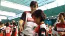 Maria Kristin, pelatih PB Djarum, membagikan amplop berisi pengumuman lolos tidaknya peserta dalam Audisi Grand Final Djarum Beasiswa Bulutangkis 2015. Minggu (6/9/2015). (Bola.com/Arief Bagus)