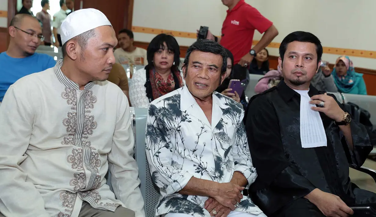 Turut hadir dalam sidang kali ini ayahnya, Rhoma Irama berbalut kemeja putih bermotif splash hitam. Ayah Ridho duduk di bangku pengunjung sidang deretan paling depan. (Deki prayoga/Bintang.com)