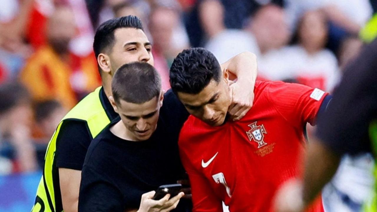 Namun saat laga Piala Eropa 2024 antara Portugal Vs Turki, pemain Al-Nassr itu mendapat serbuan dari fans fanatic yang memburu berfoto dengannya.<br>Para penggemar itu sampai nekat menerobos lapangan demi bisa berfoto bersama CR7, berikut aksi penggemar y