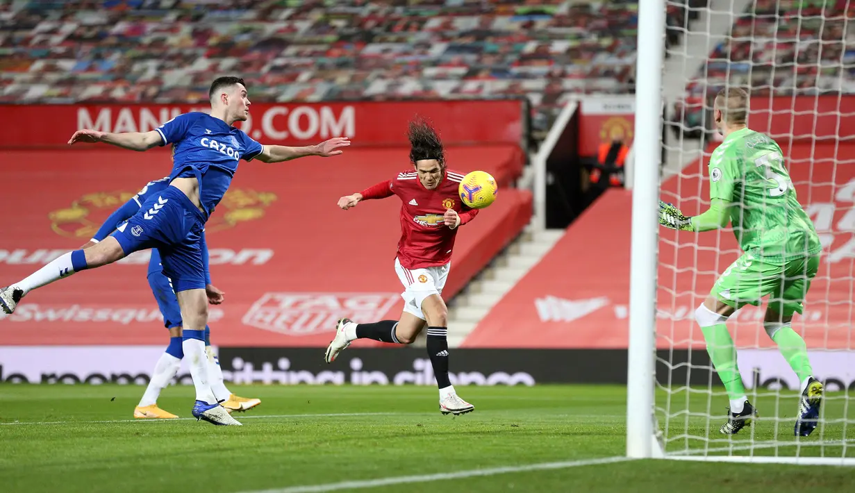 Striker Manchester United (MU), Edinson Cavani (tengah) mencetak gol pertama timnya ke gawang Everton pada laga pekan ke-23 Liga Inggris 2020/2021 di Old Trafford, Minggu dinihari WIB (7/2/2021). MU mampu bermain imbang 3-3 saat menjamu Everton. (Alex Pantling/POOL/AFP)