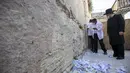 Petugas membersihkan catatan doa yang ditempatkan jemaah di celah-celah Tembok Barat, tempat doa paling suci Yudaisme, di Kota Tua Yerusalem, Rabu (25/8/2021). Menjelang tahun baru Yahudi, Tembok Barat mulai dibersihkan untuk memberi ruang bagi catatan baru jemaah berdoa. (AP Photo/Ariel Schalit)