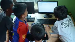 Sejumlah anak mengakses internet dari komputer yang disediakan pemkot di kawasan pemukiman kumuh Kelurahan 3-4 Ulu Palembang, Sumatera Selatan, Kamis (5/4). Sarana tersebut disediakan merupakan bagian dari program gemar membaca dan melek internet. (Antara)
