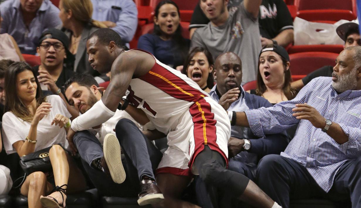 Guard Miami Heat, Dion Waiters terjatuh kearah penonton saat melawan Orlando Magic pada laga NBA preseason basketball game, di Miami (19/10/2016) WIB. (AP/Wilfredo Lee)