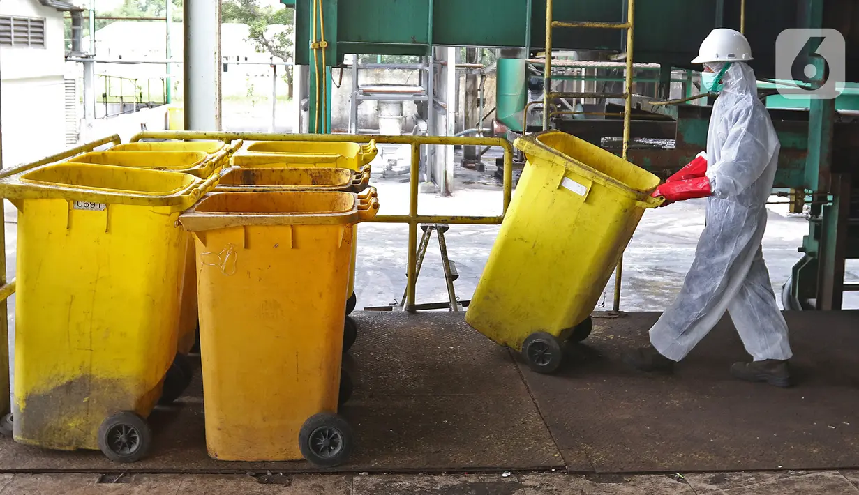 Petugas membawa "Wheeled Bin" atau tempat sampah untuk limbah B3 medis Infeksius Covid-19 usai dimusnahkan di PT Jasa Medivest, Karawang, Jawa Barat, Kamis (10/12/2020).  PT Jasa Medivest telah memusnahkan lebih dari 500 ton limbah B3 medis dari Maret - Oktober 2020. (Liputan6.com/Herman Zakharia)