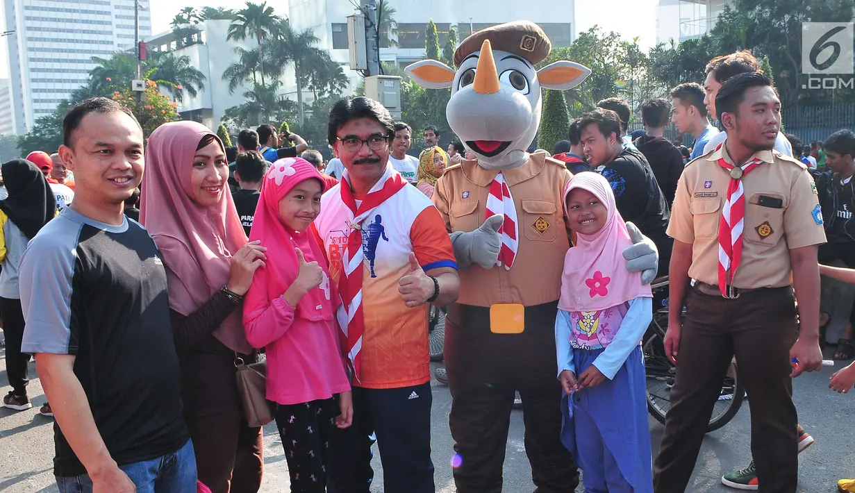Warga berfoto bersama dengan Ketua Kwartir Nasional (Kwarnas) Gerakan Pramuka Adhyaksa Dault dalam acara aksi Satu Indonesia di area CFD, Bundaran HI, Minggu (30/7). (Liputan6.com/Helmi Afandi)