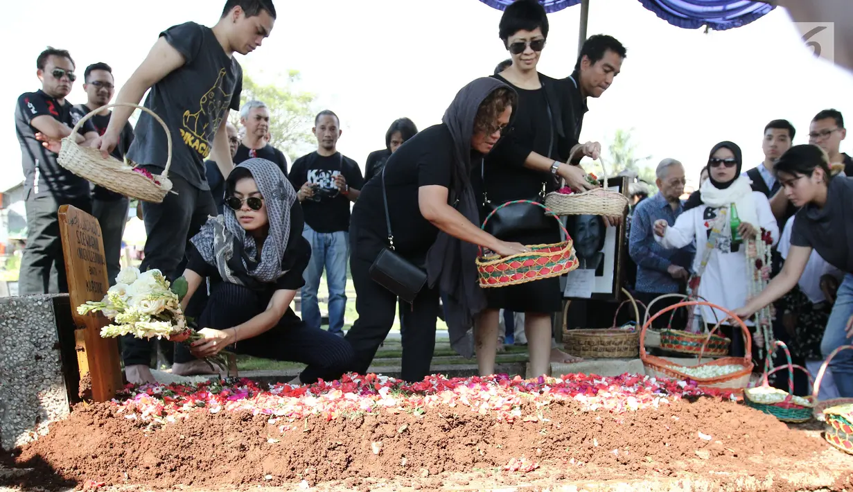 Eva Celia menaruh bunga di pemakaman neneknya, Nien Lesmana di TPU Tanah Kusir, Jakarta, Rabu (28/6). Ibu dari Indra Lesmana dan Mira Lesmana meninggal dunia pada usai 88 tahun. (Liputan6.com/Herman Zakharia)