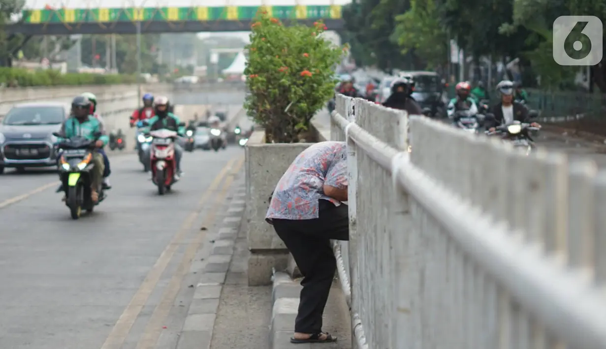 Warga menerobos celah pagar pembatas jalan di depan Stasiun Pasar Minggu, Jakarta, Rabu (16/10/2019). Jauhnya jembatan penyeberangan orang (JPO) membuat warga memanfaatkan celah pagar pembatas tersebut sebagai akses menyeberang, meski berbahaya bagi keselamatan. (Liputan6.com/Immanuel Antonius)