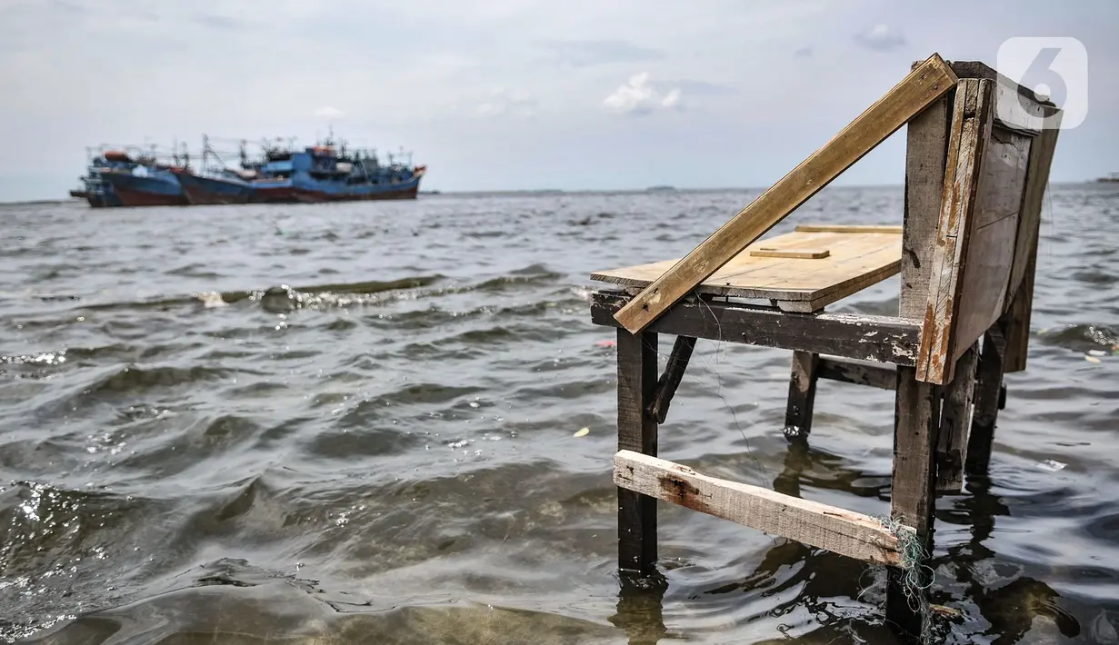 Sebuah bangku saat terendam banjir rob di Pelabuhan Kali Adem, Muara Angke, Jakarta, Kamis (22/10/2020). Banjir akibat air pasang dengan ketinggian mencapai 30 cm tersebut telah merendam kawasan Pelabuhan Kali Adem dan sudah berlangsung selama lima hari. (merdeka.com/Iqbal S. Nugroho)